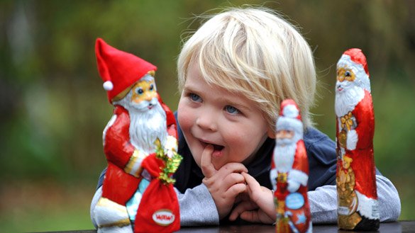Kind spielt mit einem Schokoladen-Nikolaus